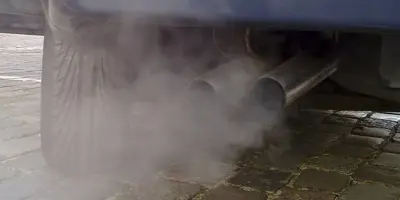 Close up of a car exhaust pipe and a cloud of gas emissions.